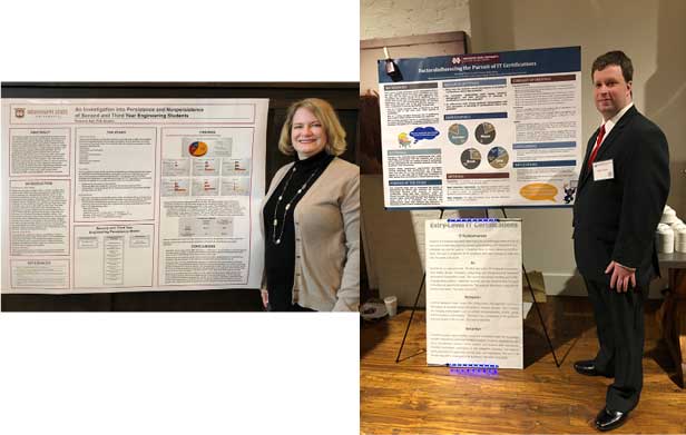 Grad students pose next to posters