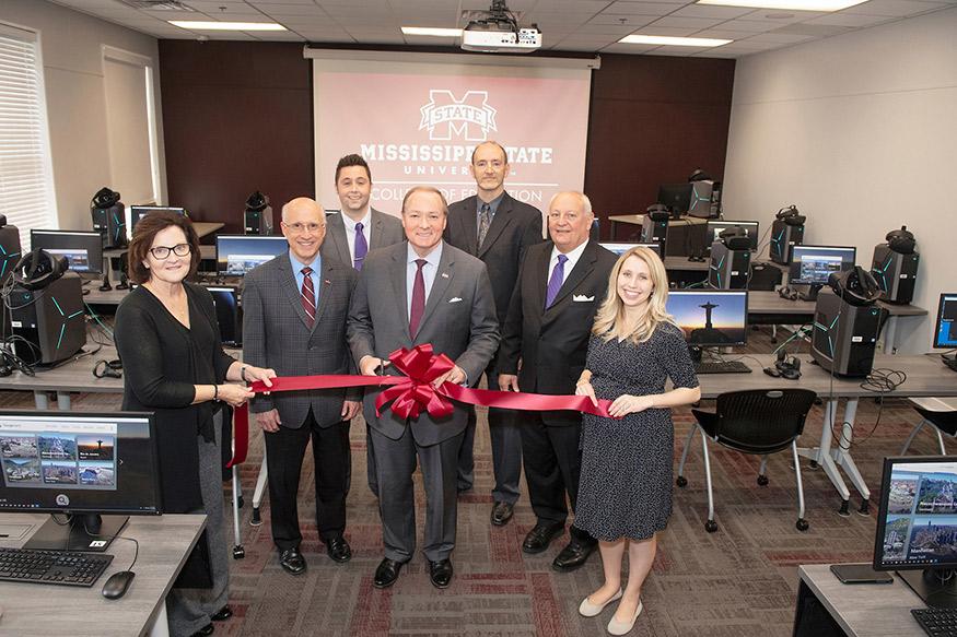 Mississippi State leaders celebrated the opening of the College of Education’s new Virtual Reality Academy and Lab Thursday [Nov. 14]. Pictured (front, l-r) are College of Education Associate Dean Teresa Jayroe; Provost and Executive Vice President David Shaw; MSU President Mark E. Keenum; College of Education Dean Richard Blackbourn; and T.K. Martin Center for Technology and Disability Director Kasee Stratton-Gadke; (back, l-r) Department of Counseling, Educational Psychology and Foundations Head Daniel Ga